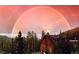 Charming mountain home beneath a vibrant double rainbow, nestled among lush trees and offering scenic views at 197 Sawmill Ln, Idaho Springs, CO 80452