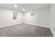 This is an empty basement bedroom or living area with carpet and two small windows at 3565 S Holly St, Denver, CO 80237