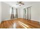 Bright bedroom featuring wood floors, a ceiling fan, and natural light from two windows at 1731 Locust St, Denver, CO 80220