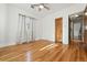 Empty bedroom featuring wood floors, a ceiling fan, natural light, and warm wood doors at 1731 Locust St, Denver, CO 80220