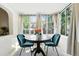 Bright dining room with large windows, elegant curtains, and a stylish round table with comfortable velvet chairs at 1731 Locust St, Denver, CO 80220