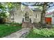 A cozy home features a unique brick exterior and meticulously maintained yard, surrounded by mature shade trees at 1731 Locust St, Denver, CO 80220