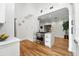 Bright kitchen features stainless steel stove, white cabinets, and hardwood floors, with an open layout to the living area at 1731 Locust St, Denver, CO 80220