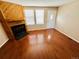 Bright living room featuring a wood-burning fireplace, hardwood flooring, and ample natural light streaming through large windows at 4111 E 94Th Ave # E, Thornton, CO 80229