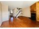 Inviting living room featuring gleaming hardwood floors, a cozy fireplace, and an open staircase to the upper level at 4111 E 94Th Ave # E, Thornton, CO 80229