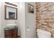 Charming half bath features a decorative mirror, brick accent wall, and vessel sink at 9478 E 108Th Ave, Commerce City, CO 80640