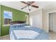 Bedroom featuring a ceiling fan, two windows and green accent wall at 9478 E 108Th Ave, Commerce City, CO 80640