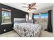 Bright bedroom features a ceiling fan, modern accent wall, and sun-filled windows at 9478 E 108Th Ave, Commerce City, CO 80640