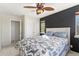 Bright bedroom features a ceiling fan, closet, modern accent wall, and sunny windows at 9478 E 108Th Ave, Commerce City, CO 80640
