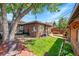 Charming brick home featuring a lush, manicured backyard with patio and greenery at 2901 Monaco Pkwy, Denver, CO 80207