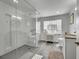 Modern bathroom with dual vanities, a glass-enclosed shower, and a window providing ample natural light at 2901 Monaco Pkwy, Denver, CO 80207