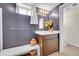 Stylish bathroom with dark walls, a bench, a vanity, and a decorative mirror and lighting fixture at 2901 Monaco Pkwy, Denver, CO 80207
