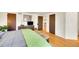 Bright bedroom featuring hardwood floors, a dresser with a TV, and a queen bed with unique furnishings at 2901 Monaco Pkwy, Denver, CO 80207