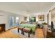 Cozy bedroom with hardwood floors, a window view, seating and a queen-sized bed with a gray comforter at 2901 Monaco Pkwy, Denver, CO 80207