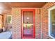 Close-up of a classic brick home featuring a striking red front door and brickwork at 2901 Monaco Pkwy, Denver, CO 80207