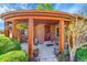 Inviting covered front porch with brick accents, decorative hanging plants, and updated lighting at 2901 Monaco Pkwy, Denver, CO 80207