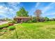 Charming brick home with lush landscaping, mature trees, and a well-manicured lawn at 2901 Monaco Pkwy, Denver, CO 80207