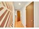 Hallway with decorative walls, natural light, hardwood floors, and doorway access to rooms at 2901 Monaco Pkwy, Denver, CO 80207