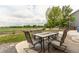 Inviting back patio with dining set overlooking expansive green space and a wooden fence at 11183 E 114Th Ave, Commerce City, CO 80640