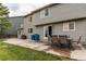 A spacious backyard with a concrete patio, dining set, grassy area, and home's exterior at 11183 E 114Th Ave, Commerce City, CO 80640