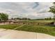 The backyard includes a lawn, concrete patio, and stone pathway bordered by a wooden fence with expansive field views at 11183 E 114Th Ave, Commerce City, CO 80640