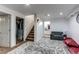 Basement area featuring a staircase, a gray sofa, and access to a bathroom at 11183 E 114Th Ave, Commerce City, CO 80640