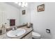 Well-lit half-bathroom with a single sink vanity, toilet, and decorative artwork at 11183 E 114Th Ave, Commerce City, CO 80640