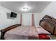 Cozy bedroom featuring a TV, plush bedding, and a dark wooden headboard at 11183 E 114Th Ave, Commerce City, CO 80640