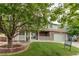 Charming two-story home with stone facade, front porch, lush lawn, and mature tree at 11183 E 114Th Ave, Commerce City, CO 80640