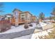 Backyard with wooden deck featuring stone pillar supports and partial snow coverage at 22029 E Irish Dr, Aurora, CO 80016