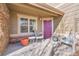 Inviting entryway with a vibrant purple door, chairs, and a charming welcome setting at 22029 E Irish Dr, Aurora, CO 80016