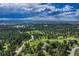 Picturesque aerial view showcasing a home surrounded by trees and a winding road leading to a serene lake at 5519 Ponderosa Dr, Parker, CO 80134