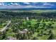 Panoramic aerial shot captures homes nestled amidst lush trees and green meadows, with distant mountains at 5519 Ponderosa Dr, Parker, CO 80134