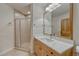 Bright bathroom with wood vanity, white marble countertop, and tiled walk-in shower at 5519 Ponderosa Dr, Parker, CO 80134
