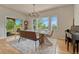 Sunlit dining room with an outdoor view, modern chandelier, and black baby grand piano at 5519 Ponderosa Dr, Parker, CO 80134