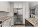 Modern kitchen featuring stainless steel refrigerator, granite countertops and ample cabinet space at 9624 W Chatfield Ave # D, Littleton, CO 80128
