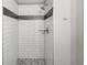 Elegant bathroom with white subway tile shower, glass shelves and pebble floor tile at 9624 W Chatfield Ave # D, Littleton, CO 80128