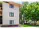 View of the exterior of this condo with well-maintained lawn and established trees at 2201 Sable Blvd # 1003, Aurora, CO 80011