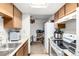 Galley-style kitchen features wooden cabinetry, a skylight, and white appliances at 2201 Sable Blvd # 1003, Aurora, CO 80011