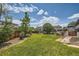 Well-manicured backyard with lush green lawn, mature trees, and wooden fencing at 2150 Wagon Way, Louisville, CO 80027