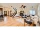 Open-concept living room with hardwood floors, stone fireplace, and staircase at 2150 Wagon Way, Louisville, CO 80027
