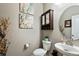 Stylish half bathroom with decorative art and a vintage-inspired mirror and vanity at 2636 Scoter Ln, Castle Rock, CO 80104