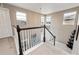 Bright hallway showcasing natural light and an open staircase with dark wood trim and white banisters at 2636 Scoter Ln, Castle Rock, CO 80104