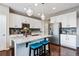 Bright kitchen featuring a large island, white cabinetry, stainless steel appliances, and hardwood floors at 2636 Scoter Ln, Castle Rock, CO 80104