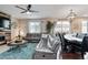 Open-concept living and dining area with a comfortable gray sectional and a rustic wood accent wall at 2636 Scoter Ln, Castle Rock, CO 80104