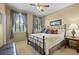 Comfortable bedroom with a metal frame bed, two windows with neutral curtains, and a ceiling fan at 19616 E Pinewood Dr, Aurora, CO 80016