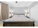 Neutral-toned bedroom featuring a black wood bed frame, neutral carpet, and two bedside lamps at 19616 E Pinewood Dr, Aurora, CO 80016