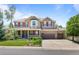 Inviting two-story home featuring a covered front porch, manicured lawn, and a three-car garage at 19616 E Pinewood Dr, Aurora, CO 80016