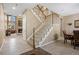 Inviting foyer featuring a staircase with wood and white railings, adjacent to a dining area at 19616 E Pinewood Dr, Aurora, CO 80016