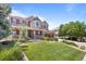 Beautifully landscaped front yard leading to a charming two-story home with a welcoming covered porch at 19616 E Pinewood Dr, Aurora, CO 80016